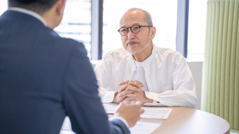認知症や相続について専門家に相談する高齢男性と相談員の面談風景