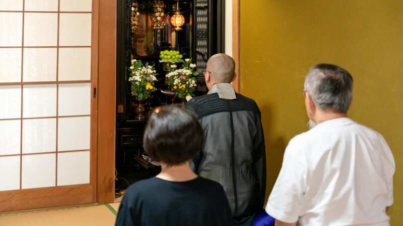 僧侶がお仏壇の前で読経し家族が手を合わせている様子｜仏壇の魂抜き・墓じまいサポートのイメージ
