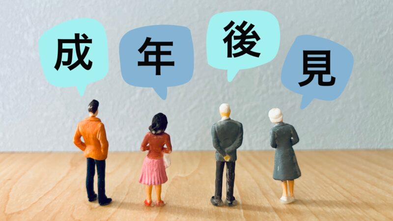 成年後見をイメージした4人の家族と高齢者のフィギュアが並び「成年後見」の文字が吹き出しで表示されている画像