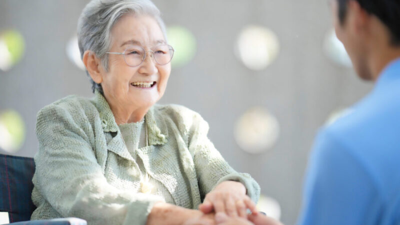 任意後見や見守り契約で安心して暮らす高齢女性と支援者の笑顔の会話イメージ｜北日本相続センター