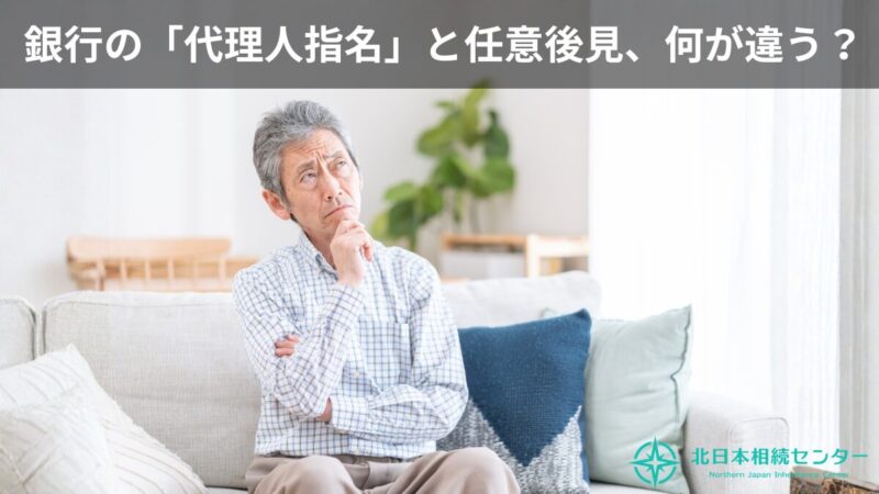 ソファに座った高齢男性が、銀行の「代理人指名」と任意後見の違いについて考え込んでいるイメージ画像